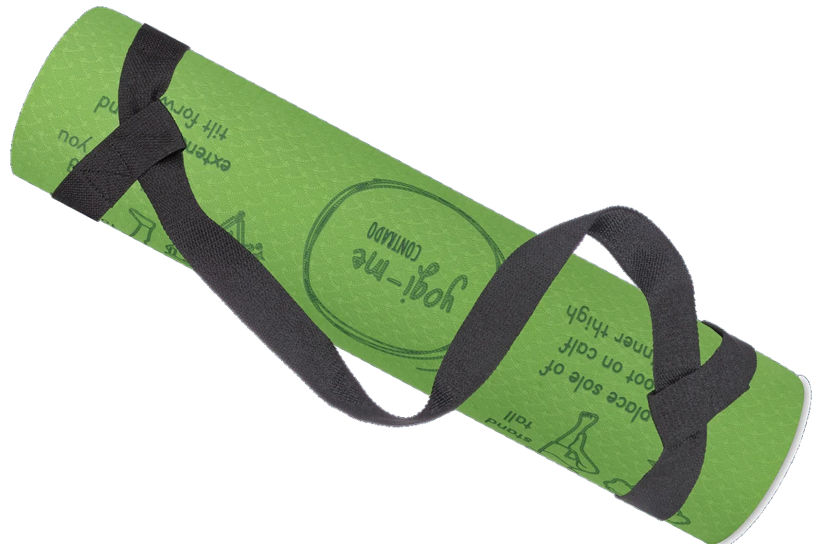 A rolled green Yogi-Me Sun Salutation children's yoga mat held by a black carry strap, with engraved pose drawings and step-by-step captions on its surface